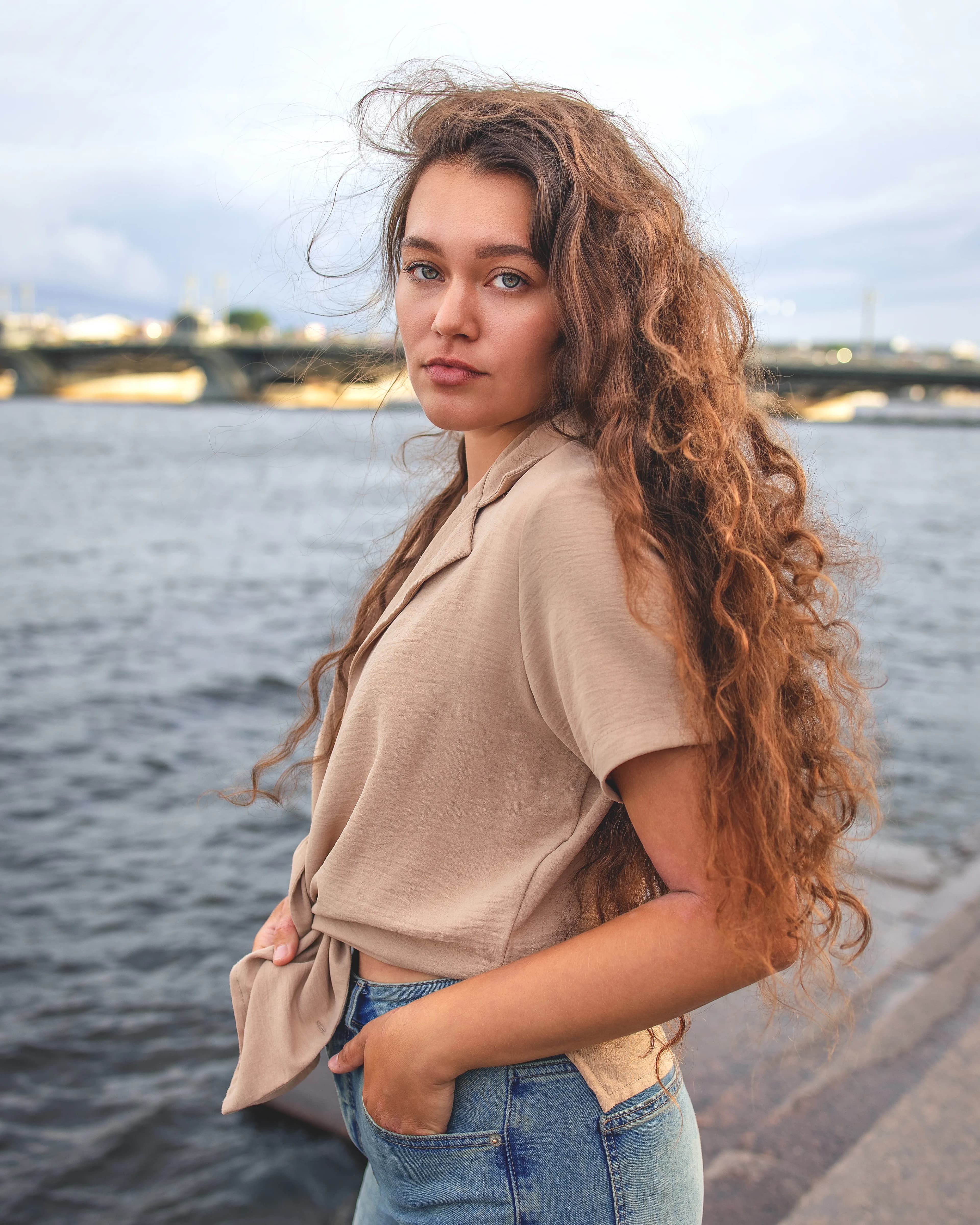 Lady with curly hair looking back by river