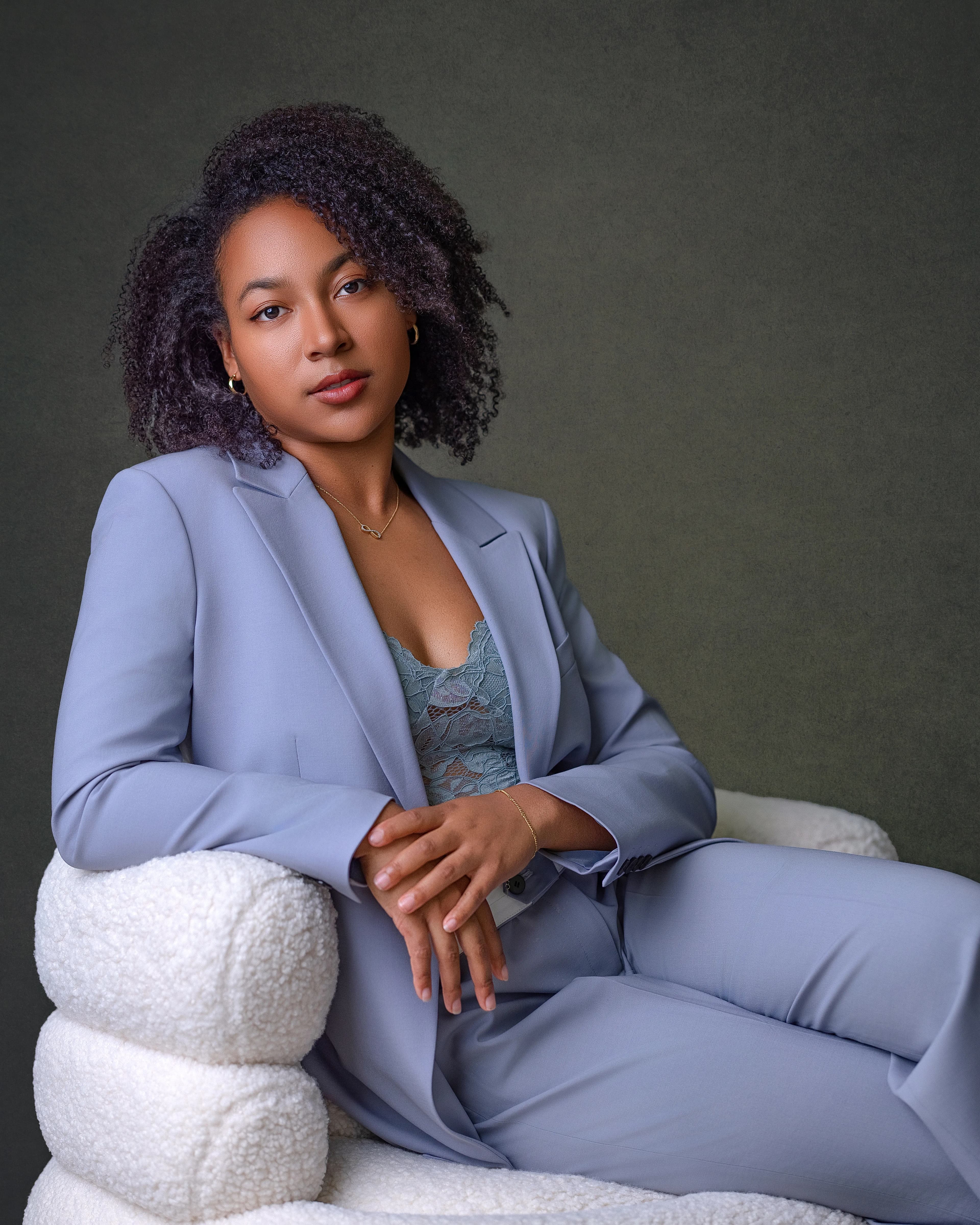 Business portrait woman light blue suit on chair